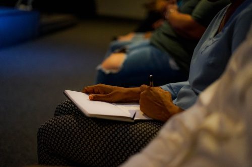 person holding pen and white paper on person lap